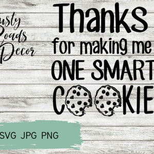 May include: A digital design on a white wood background with the text "Thanks for making me ONE SMART COOKIE." Two cookies with chocolate chips are at the bottom. The words "Dusty Roads Decor" are at the top left.