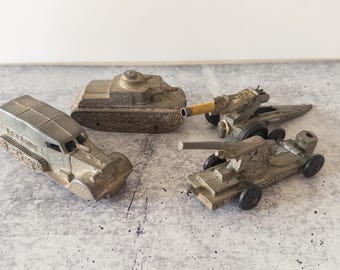 4 juguetes militares Tootsie Toys de la posguerra de la década de 1950: un tanque, dos obuses y un semioruga.