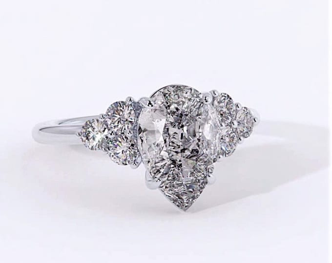 This unique teardrop cluster setting features a 2 carat IGI certified CVD lab grown Pear Cut diamond and 0.48 carats ideal round cut side diamonds