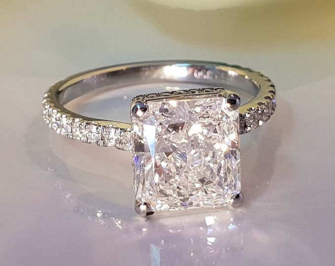 This Classic Radiant Cut Diamond Engagement Ring features a 3 Carat IGI certified CVD lab grown diamond and is accentuated by 0.50ct small diamonds