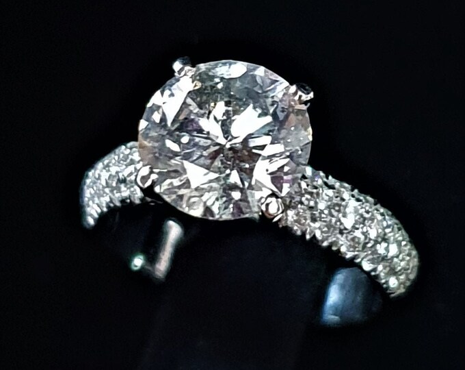 This Classic 2.50 Tcw Round Cut 3 Row Pave Set Solitaire Diamond Engagement Ring Features a 2 Carat Ideal Brilliant Cut IGI Certified Center Diamond and 0.50ct Accent Diamonds