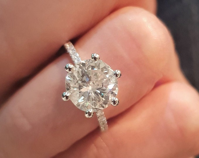 This stunning Solitaire diamond pave setting features a 3 carat IGI certified CVD lab grown diamond surrounded by a hidden halo and diamonds running up the prongs