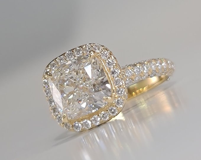 This unique double edge halo 18KT gold diamond setting features a 3 carat IGI certified CVD lab grown cushion cut diamond & 1.30 carats accent diamonds