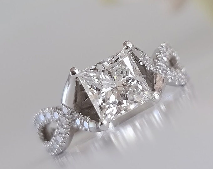 This unique twisted 14K white gold setting features a 2 carat princess cut IGI certified CVD lab grown diamond and 0.30ct princess cut side diamonds