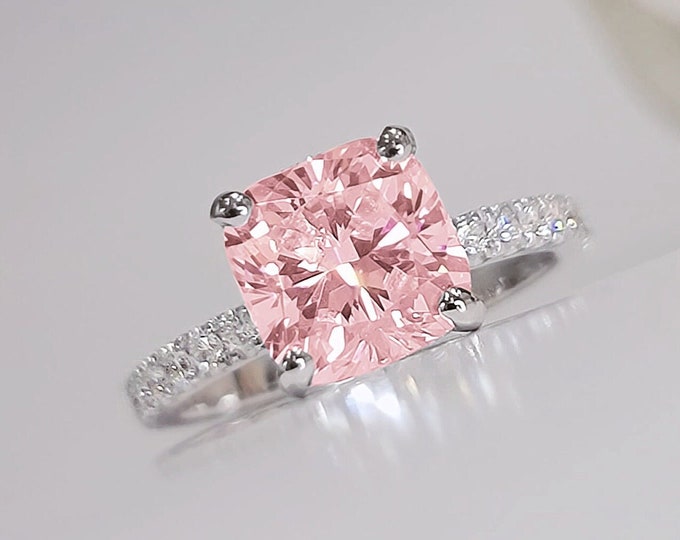 This classic solitaire pave set diamond ring features a 1.5 carat IGI certified CVD lab grown pink cushion cut diamond