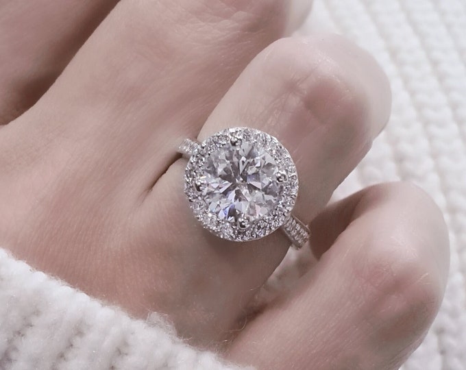This unique halo 14K gold tapered diamond setting features a 2.50 carat IGI certified CVD lab grown ideal round brilliant cut diamond & 0.67 carats accent diamonds