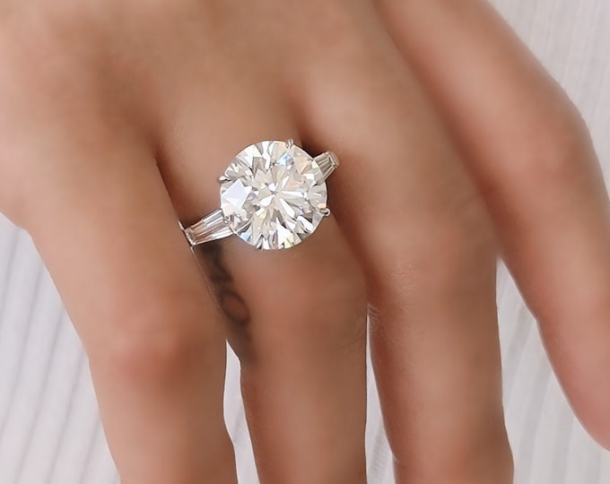 This classic timeless three Stone Diamond Ring features a 5 Carat Ideal Round Brilliant Cut IGI Certified CVD lab grown diamond accentuated with 0.80ct tapered baguette side stones