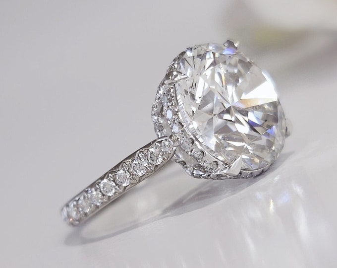 This Victorian style cathedral setting features a unique single prong 0.50 carats diamond halo and is set with a 3 carat center oval cut diamond