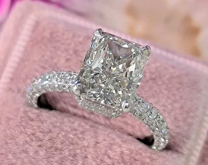 This gorgeous hidden halo setting features a 4 carat IGI Certified CVD lab grown elongated radiant cut set with 1.78ct accent diamonds