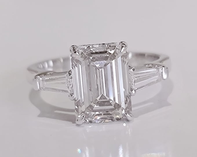 A timeless classic featuring a IGI certified 3 carat emerald cut CVD lab grown diamond complemented by two perfectly matched tapered baguette side diamonds