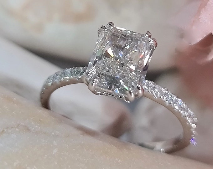 This classic hidden halo pave diamond setting features a 2 carat IGI certified CVD lab grown elongated radiant cut diamond & 0.25 carats accent diamonds
