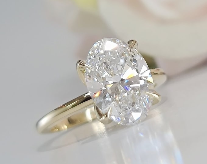This classic 14KT yellow gold setting features a 3ct oval IGI certified CVD lab grown diamond