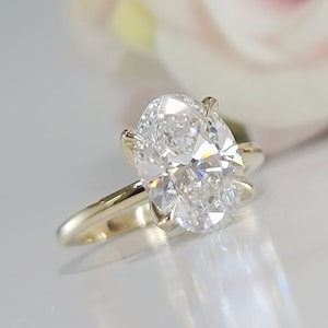 May include: A gold engagement ring with a large oval-shaped diamond.