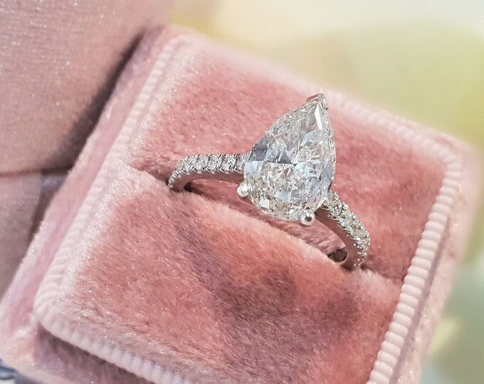 This classic pave diamond setting features a 2.50 carat Pear cut IGI certified CVD lab grown diamond with 0.26ct accent diamonds