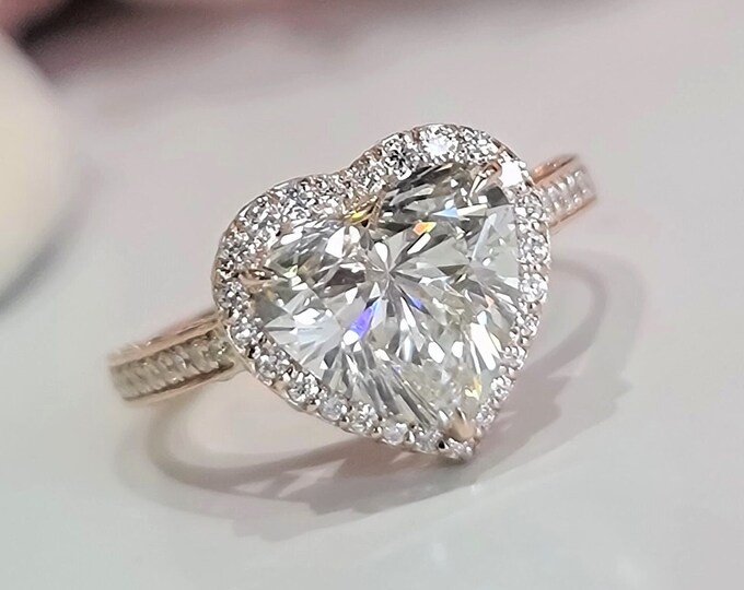 This Unique Heart Shape Halo Diamond Ring features a 3 carat Heart Diamond and is accentuated by 1.03ct pave set diamonds