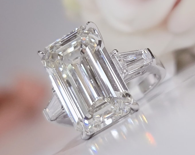 This elegant platinum 3 stone setting features a 10 carat IGI certified CVD lab grown emerald cut diamond & 0.80 carats tapered baguette side diamonds