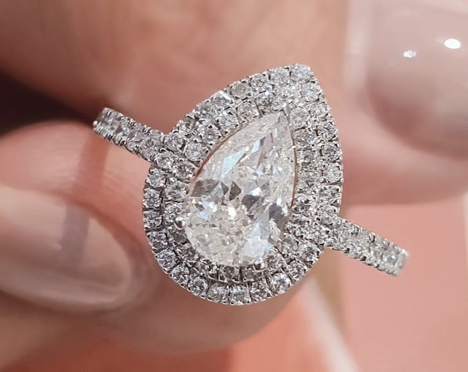 This unique double halo teardrop diamond Engagement ring set with 0.70 carats accent diamonds features a 2 carat Pear Cut IGI certified CVD lab grown diamond