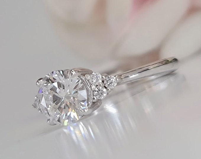 This Classic tapered band diamond setting features a 1.10 carat Round Cut IGI Certified CVD Lab Grown Diamond & 0.10 carats side diamonds