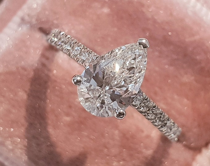 This classic pave diamond set solitaire features a 2 carat pear cut IGI certified CVD lab grown diamond & 0.22 carats accent diamonds