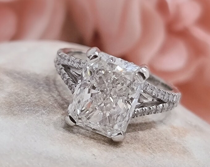 This elegant split shank  hidden halo diamond setting features a 3 carat radiant cut IGI certified CVD lab grown diamond & 0.60 carats accent diamonds