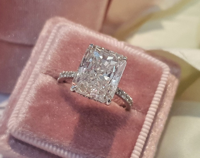 This stunning 18K gold hidden halo setting features a 4.25ct IGI certified CVD lab grown elongated radiant cut diamond and 0.67ct accent diamonds