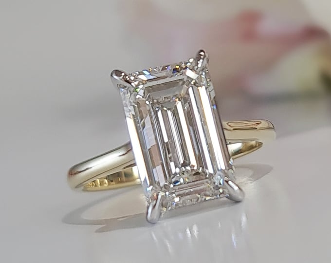 This classic 2 tone 18K gold cathedral setting features a 4.50 carat emerald cut IGI certified CVD lab grown diamond