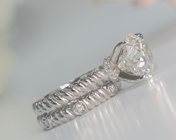 This unique twisted ring design in 14K white gold features a 3 Carat  Round Brilliant cut IGI certified CVD lab grown diamond & a hidden halo set with 0.05ct small diamonds accompanied by a matching wedding band