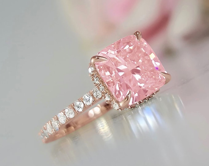 This classic rose gold hidden halo setting features a 3 carat IGI certified pink CVD lab grown cushion cut diamond & 0.47 carats accent diamonds