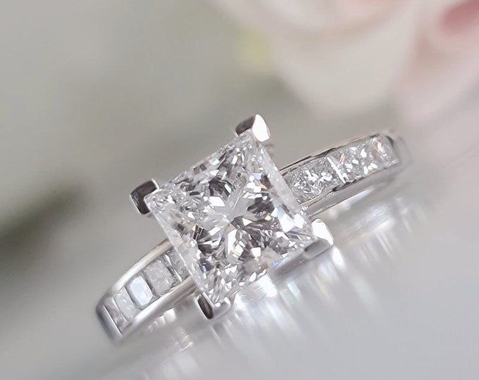 This unique channel set 14K white gold setting features a 2 carat princess cut IGI certified CVD lab grown diamond and 0.70ct princess cut side diamonds