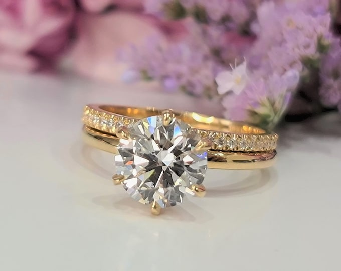 This Classic Yellow gold engagement ring set features a 2 carat IGI certified CVD lab grown diamond in a delicate 6 prong setting and flushing diamond wedding band