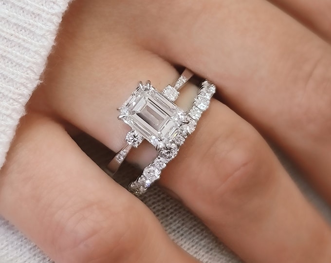 A timeless classic featuring a IGI certified 3 carat emerald cut CVD lab grown diamond and 0.13ct accent diamonds Accompanied by a 1.04ct Flushing wedding band