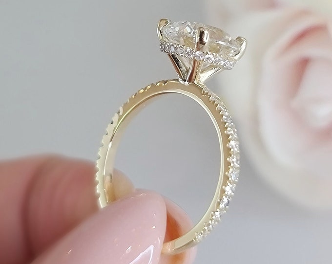 This unique solitaire hidden halo design in 14K yellow gold features a 3 Carat  Round Brilliant cut IGI certified CVD lab grown diamond & 0.42 carats accent diamonds
