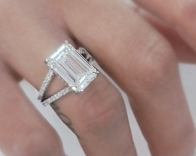This elegant platinum split shank pave diamond setting features a 5.50 carat IGI certified CVD lab grown emerald cut diamond & 0.62 carats accent diamonds
