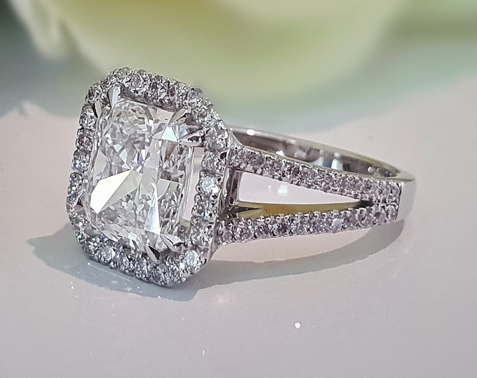 This classic split shank halo diamond setting features a 3 carat IGI certified CVD lab grown radiant cut diamond & 1.12 carats accent diamonds
