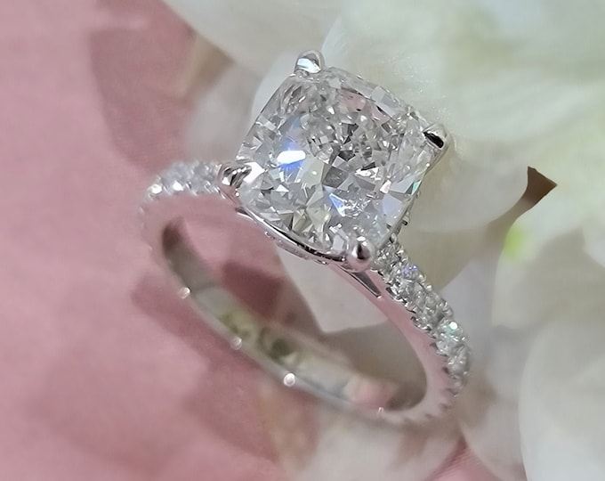This unique high profile diamond setting features a 3 carat IGI certified CVD lab grown cushion cut diamond and 0.88 carats accent diamonds