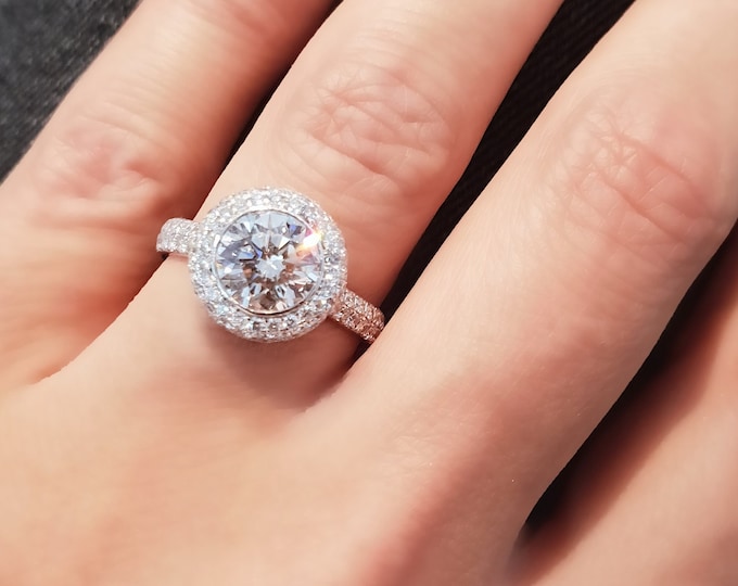 This dazzling bezel diamond halo setting features a 2 carat round brilliant cut IGI certified CVD lab grown diamond & 0.82 carats accent diamonds