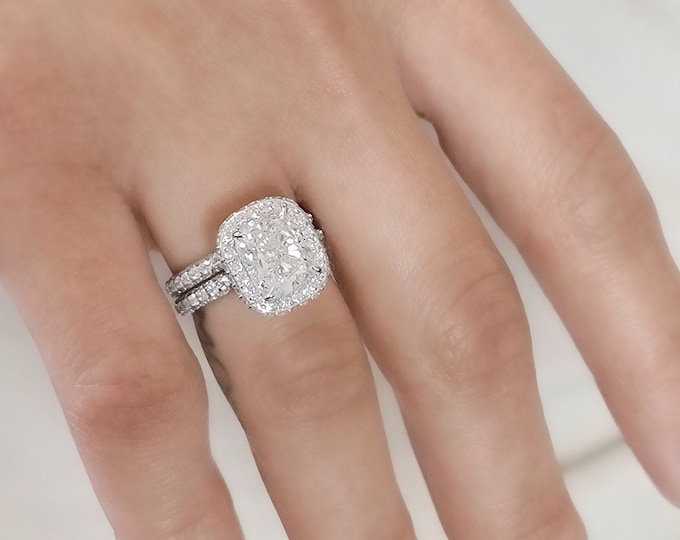 This unique double edge halo 14K gold diamond setting features a 3 carat IGI certified CVD lab grown cushion cut diamond & 1.40 carats accent diamonds accompanied by a 0.75ct matching wedding band