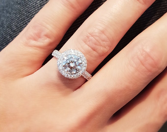 This dazzling bezel diamond halo setting features a 2 carat round brilliant cut IGI certified CVD lab grown diamond & 0.82 carats accent diamonds