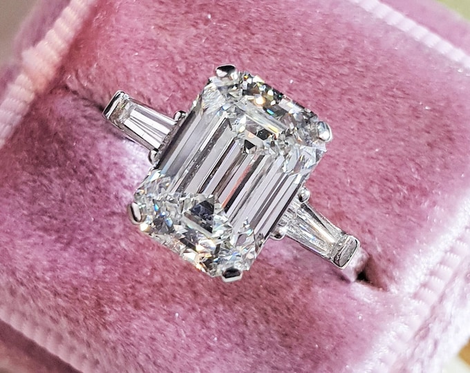 A timeless classic featuring a IGI certified 3 carat emerald cut CVD lab grown diamond complemented by two perfectly matched tapered baguette diamonds
