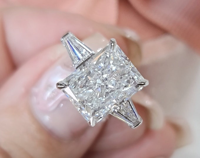 This Unique Timeless Three Stone Ring features a 3 Carat Radiant Cut IGI Certified CVD lab grown diamond accentuated with 0.50ct tapered baguette side stones