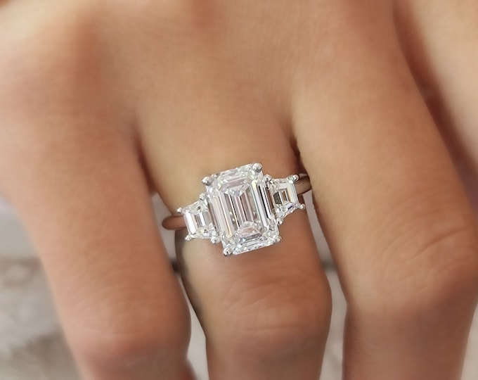 Unique Three Stone Engagement Ring set with a 3 carat IGI Certified CVD lab grown Emerald Cut Diamond accentuated with 0.80 carats trapezoid step cut side diamonds