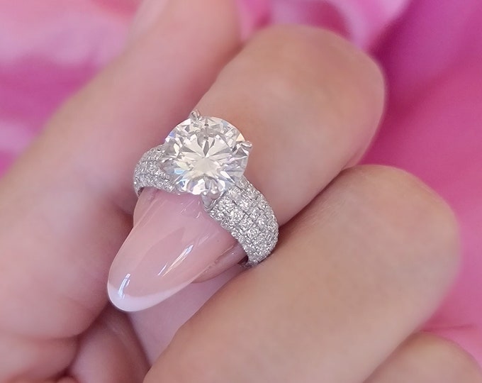 This unique wide band multi row pave diamond setting features a 2.50ct round cut IGI certified CVD lab grown diamond and 1.10ct accent diamonds