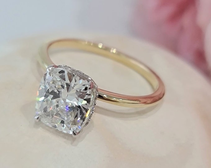 This delicate hidden halo two tone gold setting features a 2.50 Carat IGI Certified CVD lab grown Cushion Cut diamond