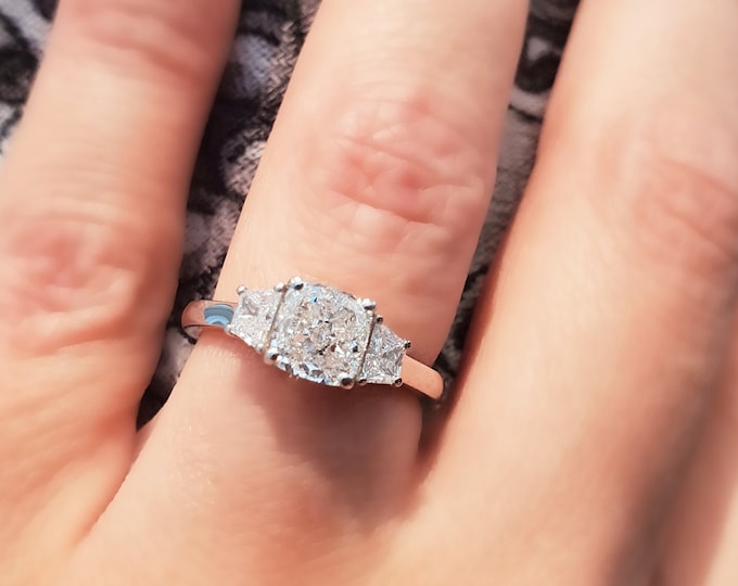 This unique 2.50 tcw three stone engagement ring features a 2 Carat Cushion Cut IGI Certified CVD lab grown diamond  accentuated with 0.50ct trapezoid cut side diamonds
