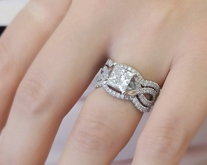 This unique twisted 14K white gold setting features a 2 carat princess cut IGI certified CVD lab grown diamond and 0.30ct princess cut side diamonds accompanied by a flushing matching 0.70 carats wedding bands
