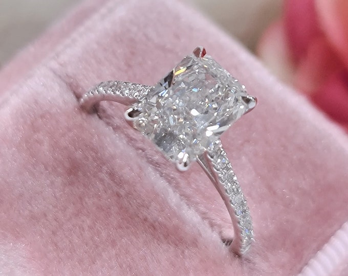 This Classic Cathedral setting features a 2.50 Carat Elongated Radiant Cut IGI certified CVD lab grown Diamond & diamond pave set band