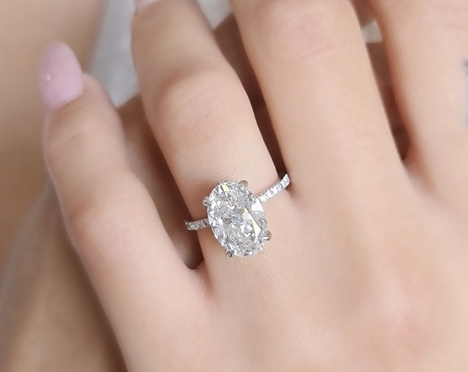 This unique 14K white gold diamond pave setting with hidden accents features a 3 carat oval cut IGI certified CVD lab grown diamond and 0.50ct accent diamonds