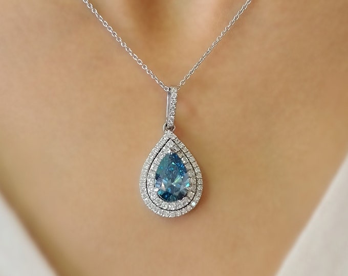 This unique 14K whit gold halo pendent necklace features a 3 carat fancy vivid blue IGI certified CVD lab grown teardrop diamond and is accentuated with 0.82 carats small diamonds