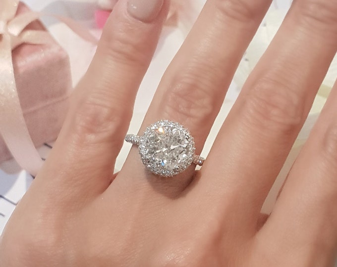 This solitaire high profile halo diamond cathedral setting features a 3 Carat IGI certified CVD lab grown diamond and 1.20ct accent diamonds