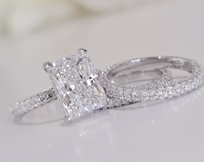 This Elegant diamond setting features a 4 carat IGI Certified CVD lab grown elongated Radiant cut diamond and 1.02ct accent diamonds accompanied by a 0.79 carats wedding band